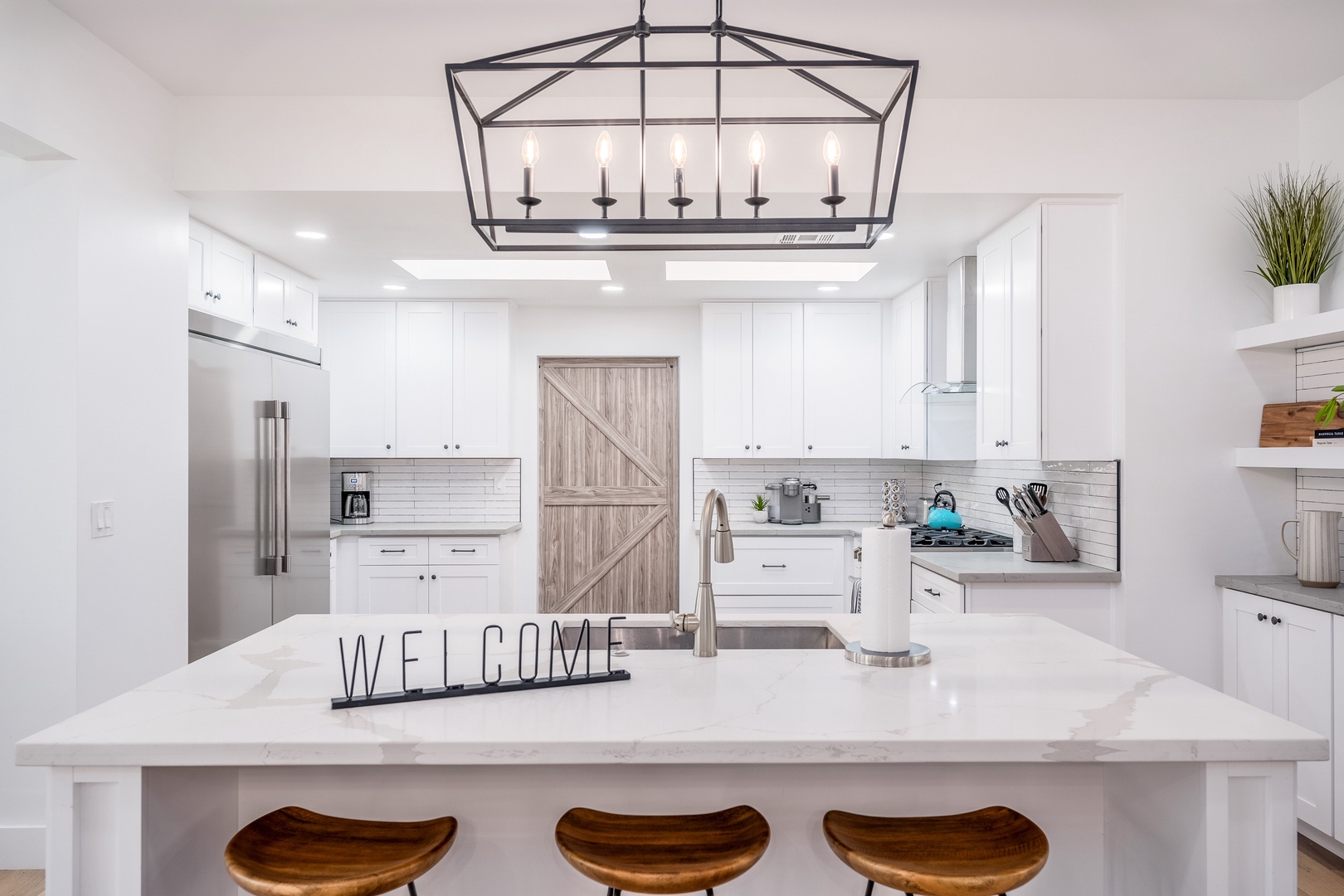 Step into your bright, modern kitchen with crisp white cabinetry, a spacious marble island, and stainless steel appliances—your home base for morning coffee and home-cooked meals.