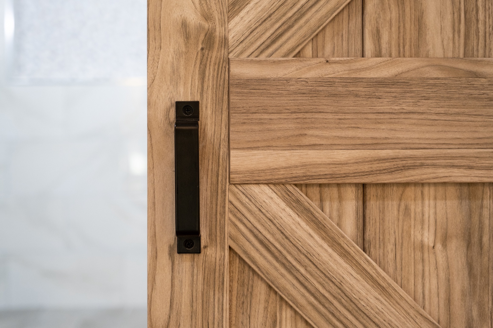 A beautiful barn-style door with chevron wood detailing and modern black hardware welcomes you into your private retreat.