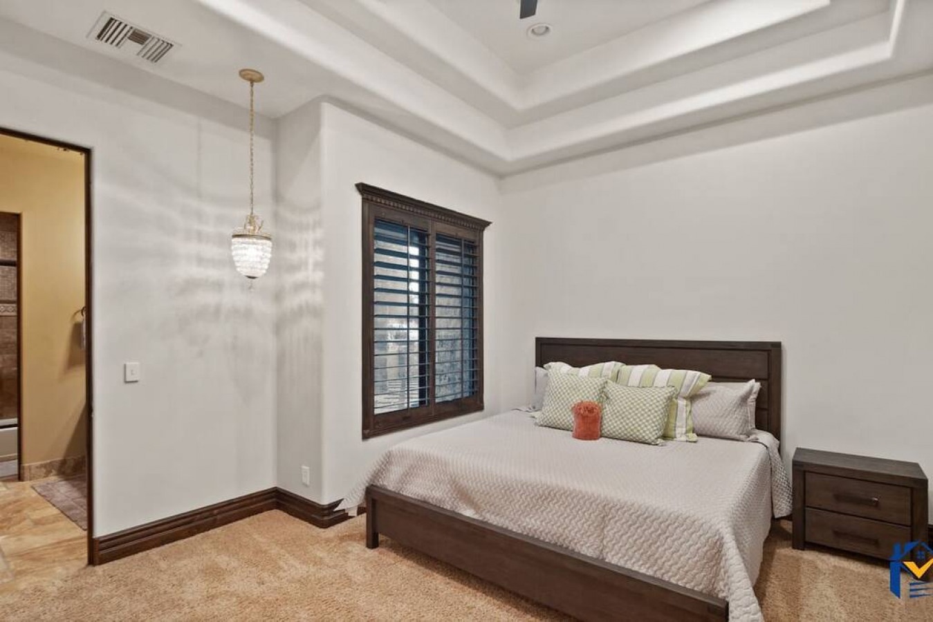 Relax in your elegant bedroom featuring a plush bed, coffered ceiling, and warm wood accents that create the perfect sanctuary for rest.