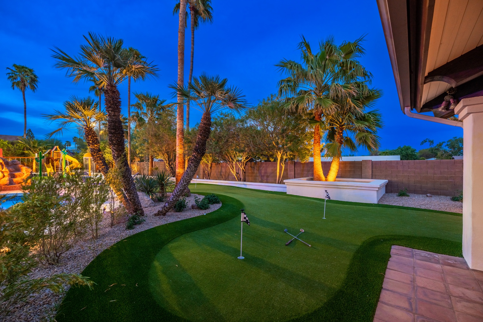 This desert-inspired backyard offers a private putting green surrounded by towering palms and landscape lighting, perfect for relaxing evenings under the Arizona sky.