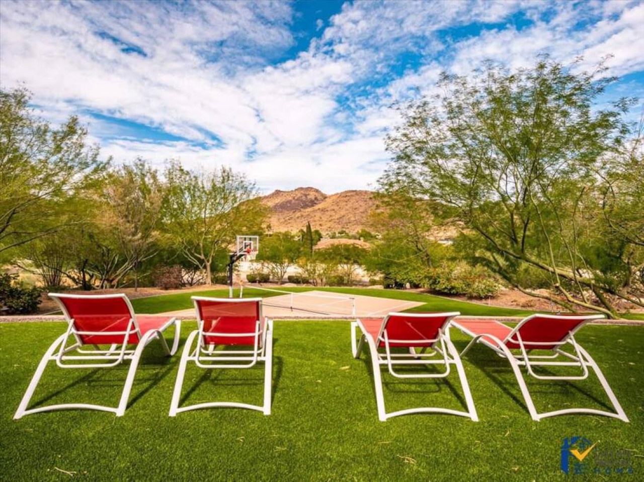 Unwind in comfortable lounge chairs on manicured grounds with stunning desert mountain views and recreational amenities nearby.