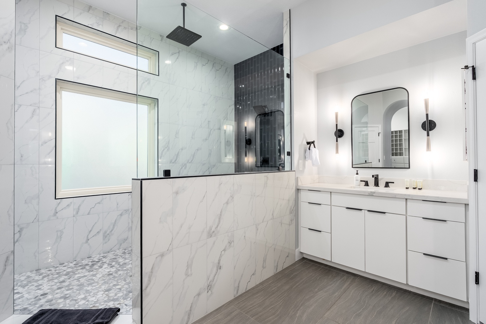 Step into your spa-like bathroom, where luxurious marble walls and a sleek walk-in shower invite you to unwind after a day of adventure.