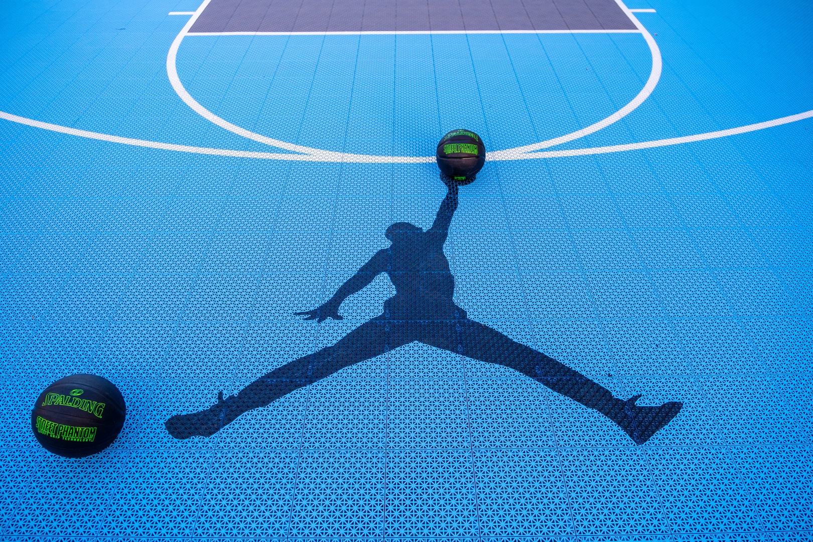 Challenge yourself on the outdoor basketball court, where bright blue surfacing and crisp white lines set the stage for competitive play and friendly games.