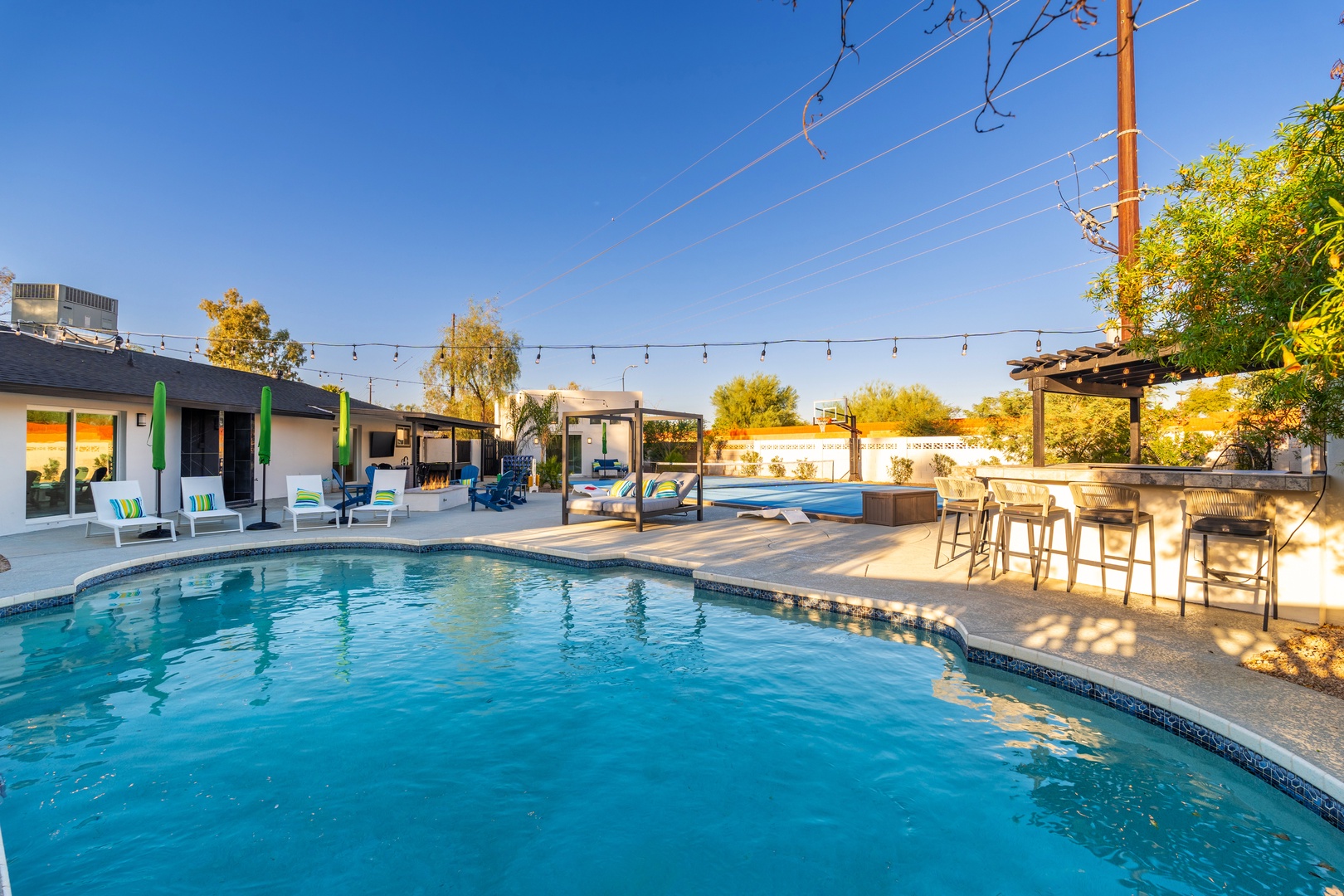 A sparkling pool surrounded by inviting loungers and an outdoor bar creates your perfect space for sun-soaked relaxation and entertaining under the desert sky.