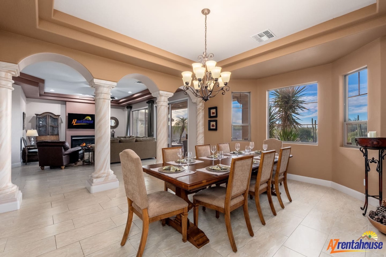 Gather around your elegant dining table beneath gleaming chandeliers, where formal meals become memorable moments with stunning desert views.