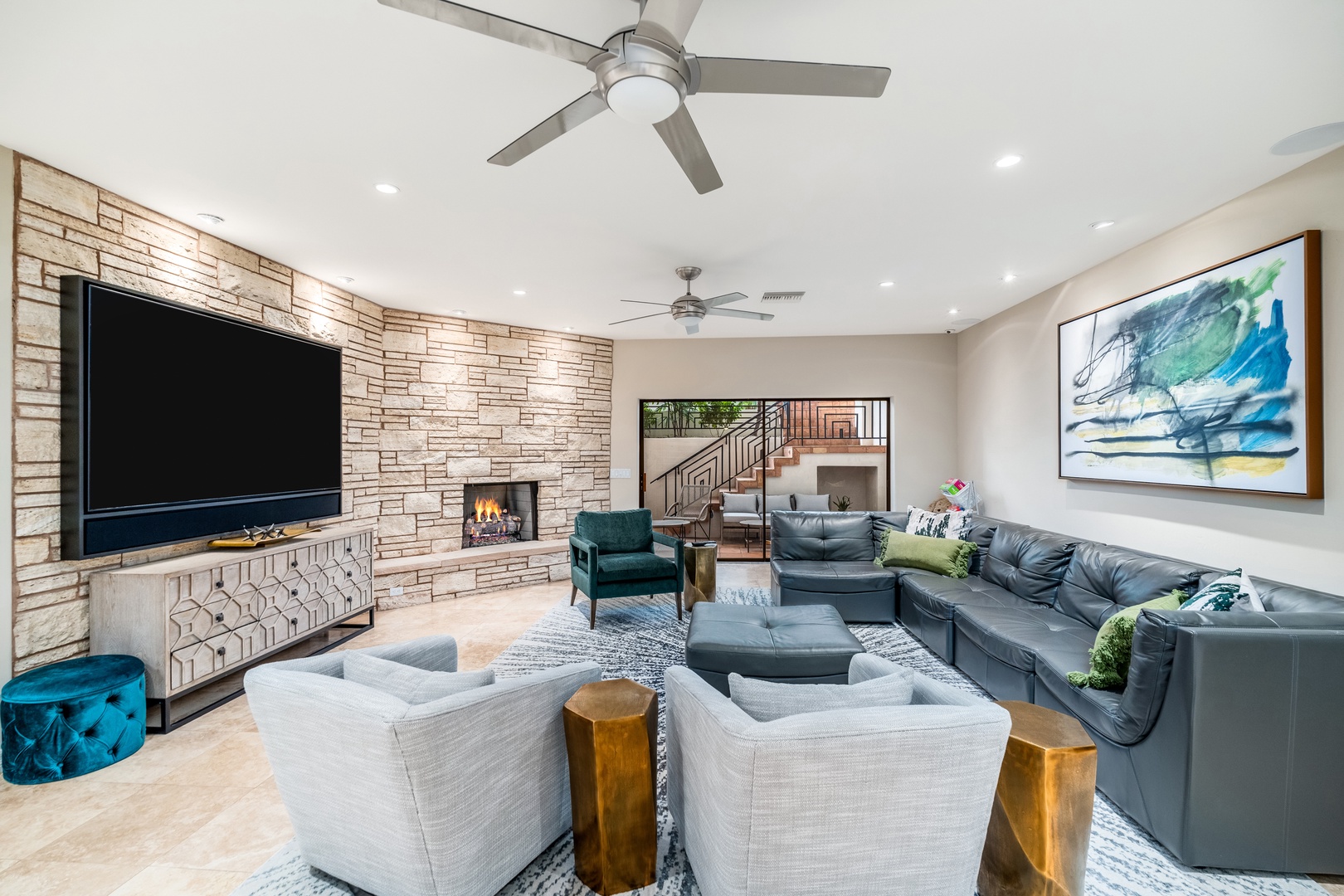 Sink into this spacious living room, where modern comfort meets warm elegance. The stone fireplace and plush seating invite relaxation after your adventures.