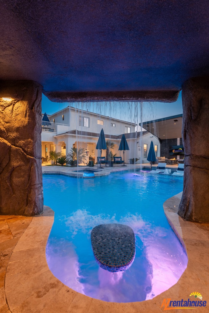 Step through this enchanting grotto into your private paradise, where illuminated waters await your evening swim beneath the starlit sky.