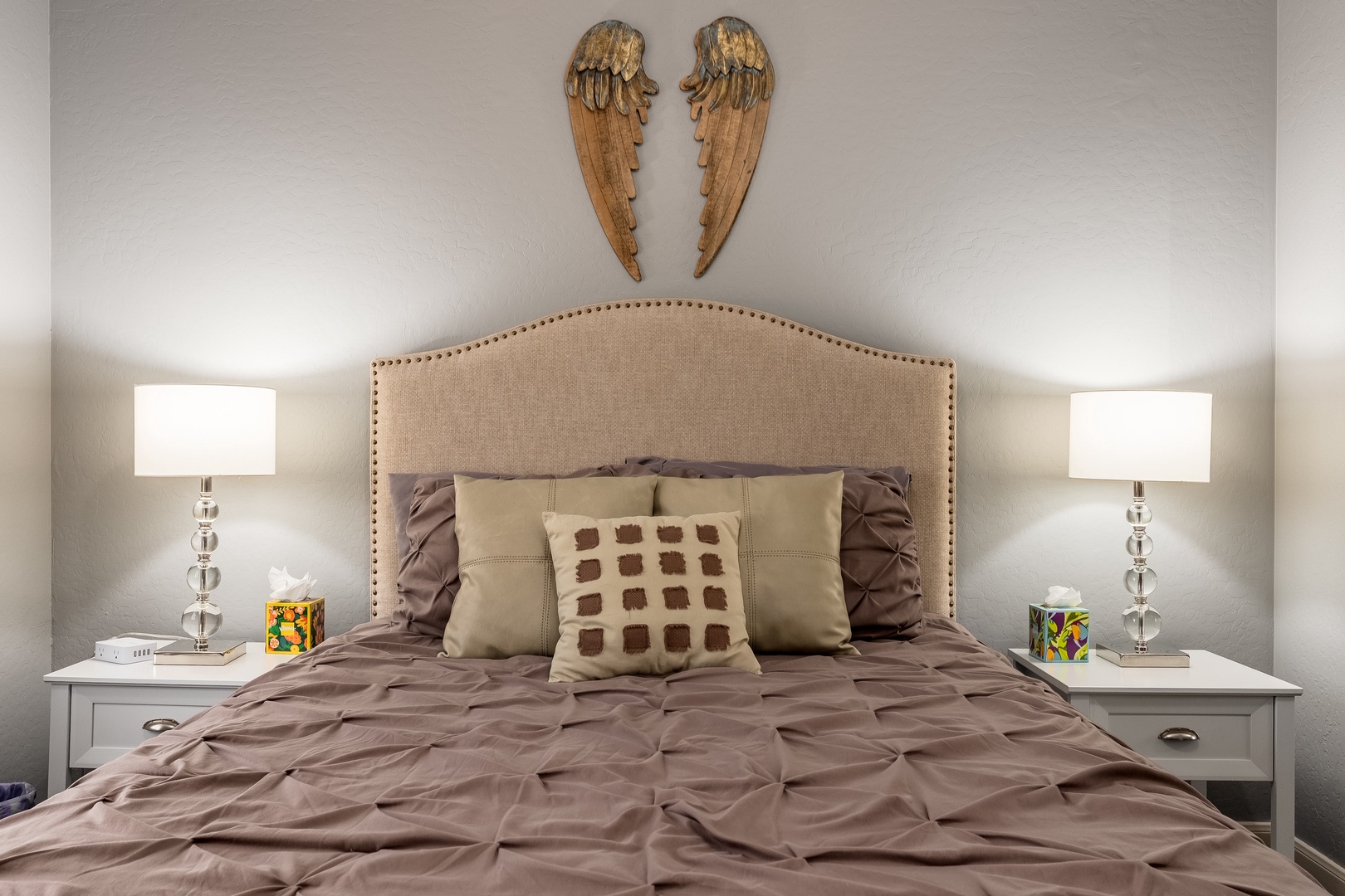 Rest easy in this peaceful bedroom with a plush bed, stylish headboard, and elegant nightstands. The soft lighting and decorative touches create a warm, inviting space for your perfect night's sleep.