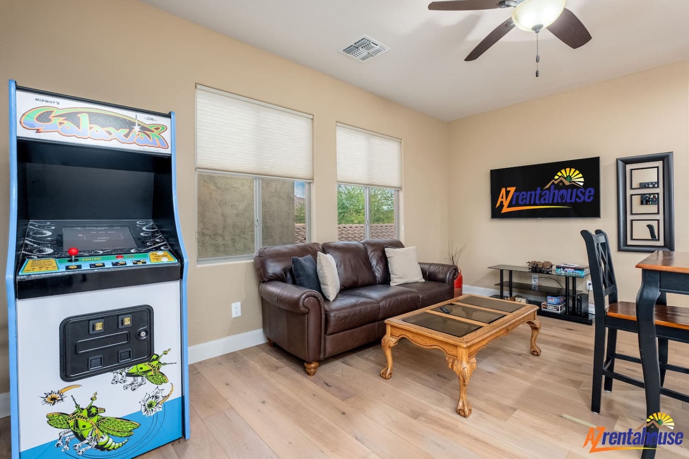 Unwind in your game room with retro arcade fun, plush leather seating, and a ceiling fan keeping you cool.