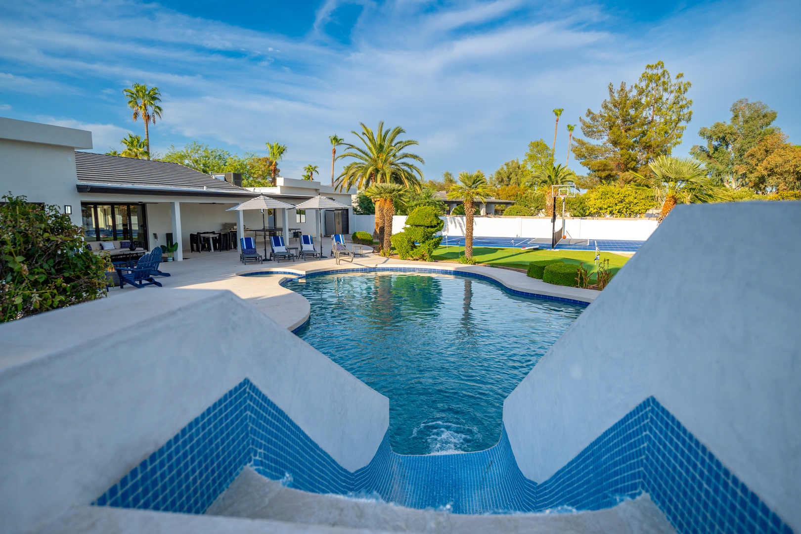 The private pool and spa await, framed by swaying palms and manicured lawns. Grab a lounge chair under the covered patio and soak in the desert sun.