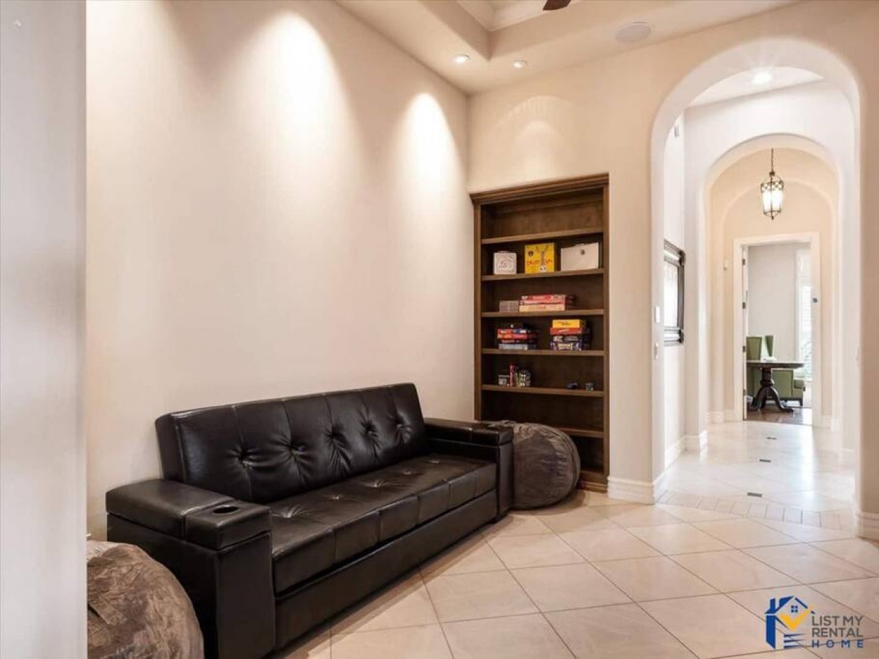 Settle into this elegant reading nook featuring a luxurious leather sofa and built-in bookshelf, perfect for quiet moments.