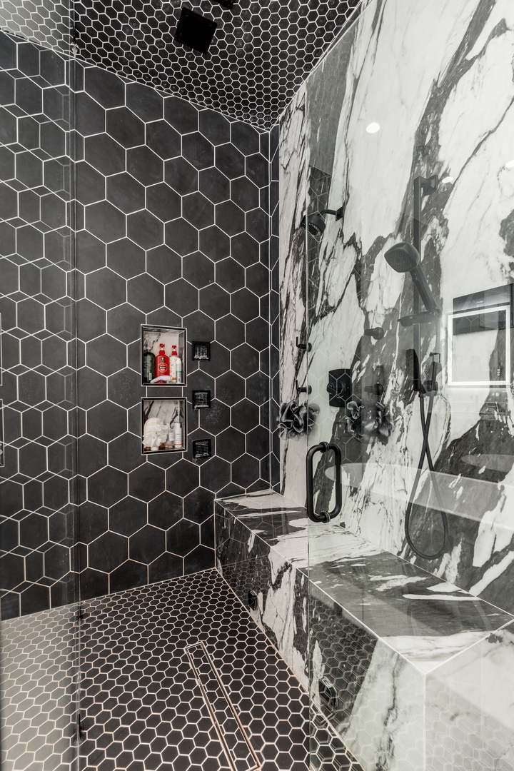 Sleek honeycomb tiles in matte black and striking marble create a bold, modern sanctuary where you can unwind under a rainfall shower surrounded by sophisticated design.