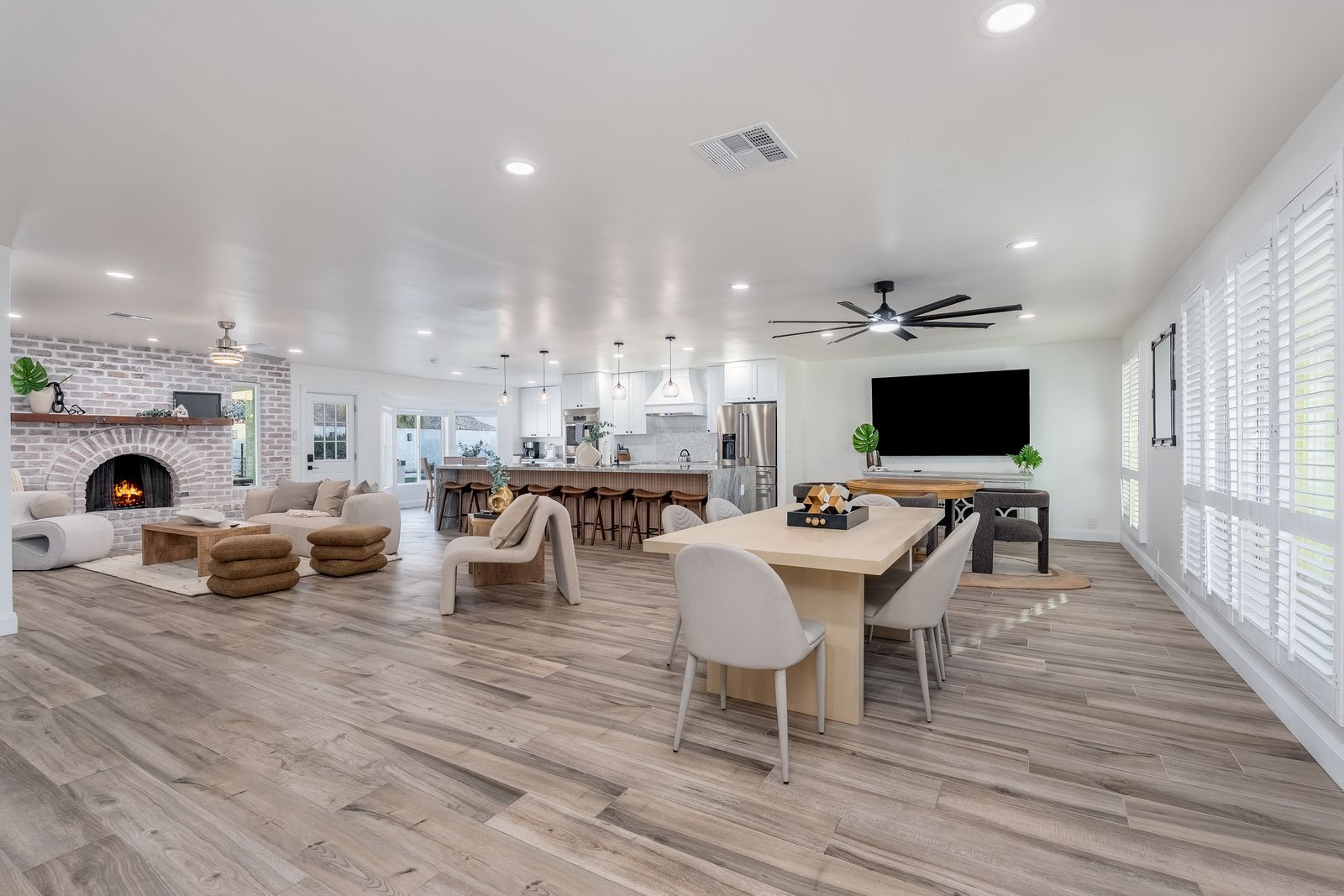 Unwind in your spacious open-concept haven, where rustic brick fireplace charm meets modern comfort. Gather at the dining table, relax by the cozy fire, or enjoy entertainment in this beautifully designed space.