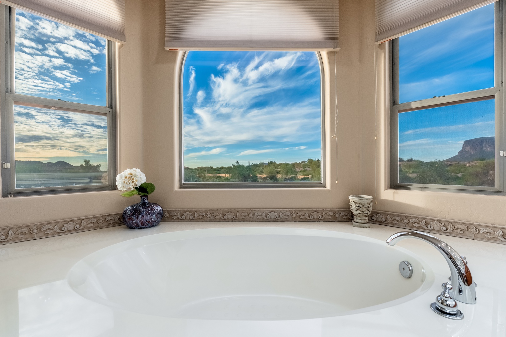 Soak in panoramic mountain and desert views from your private soaking tub, framed by three large windows that flood this peaceful retreat with natural light.