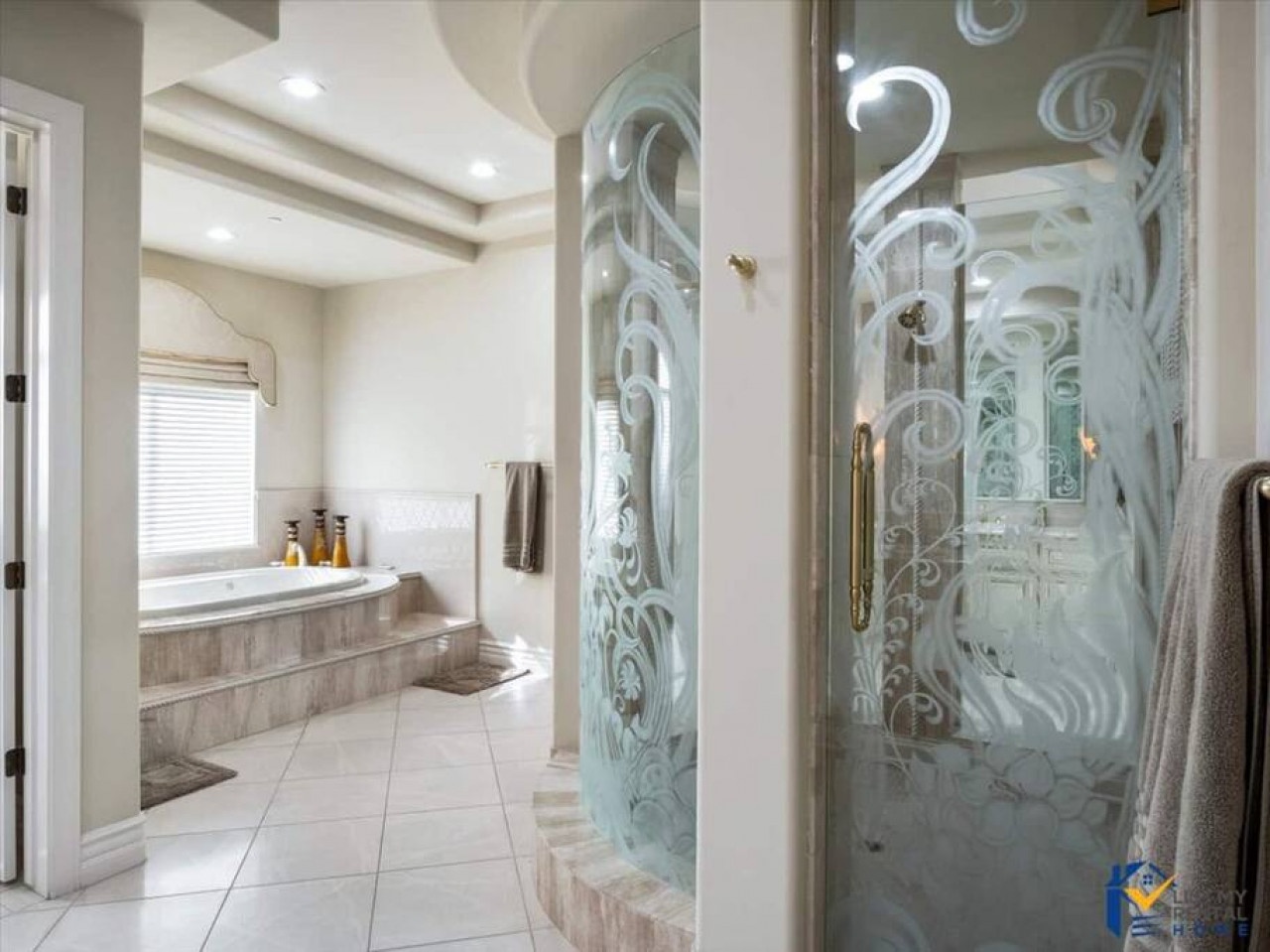 Step into your luxurious spa-like bathroom with elegant etched glass shower doors and a marble soaking tub for ultimate relaxation.