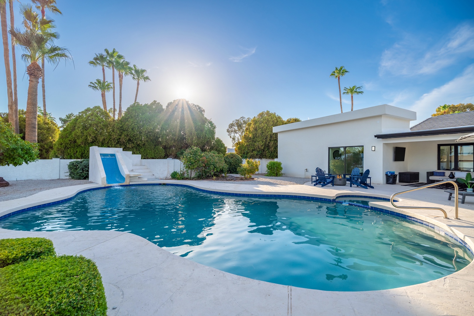 A stunning private pool oasis awaits in the desert sun, framed by swaying palms and modern architecture. Lounge under clear blue skies, take a refreshing dip, or relax poolside in this serene outdoor retreat.