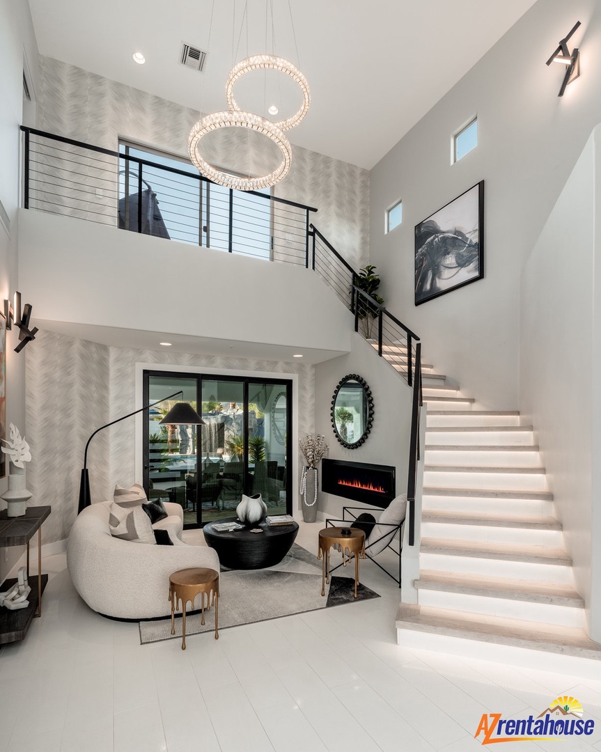 Your stunning two-story living space features soaring ceilings, designer chandelier lighting, and a cozy fireplace perfect for unwinding after exploring.