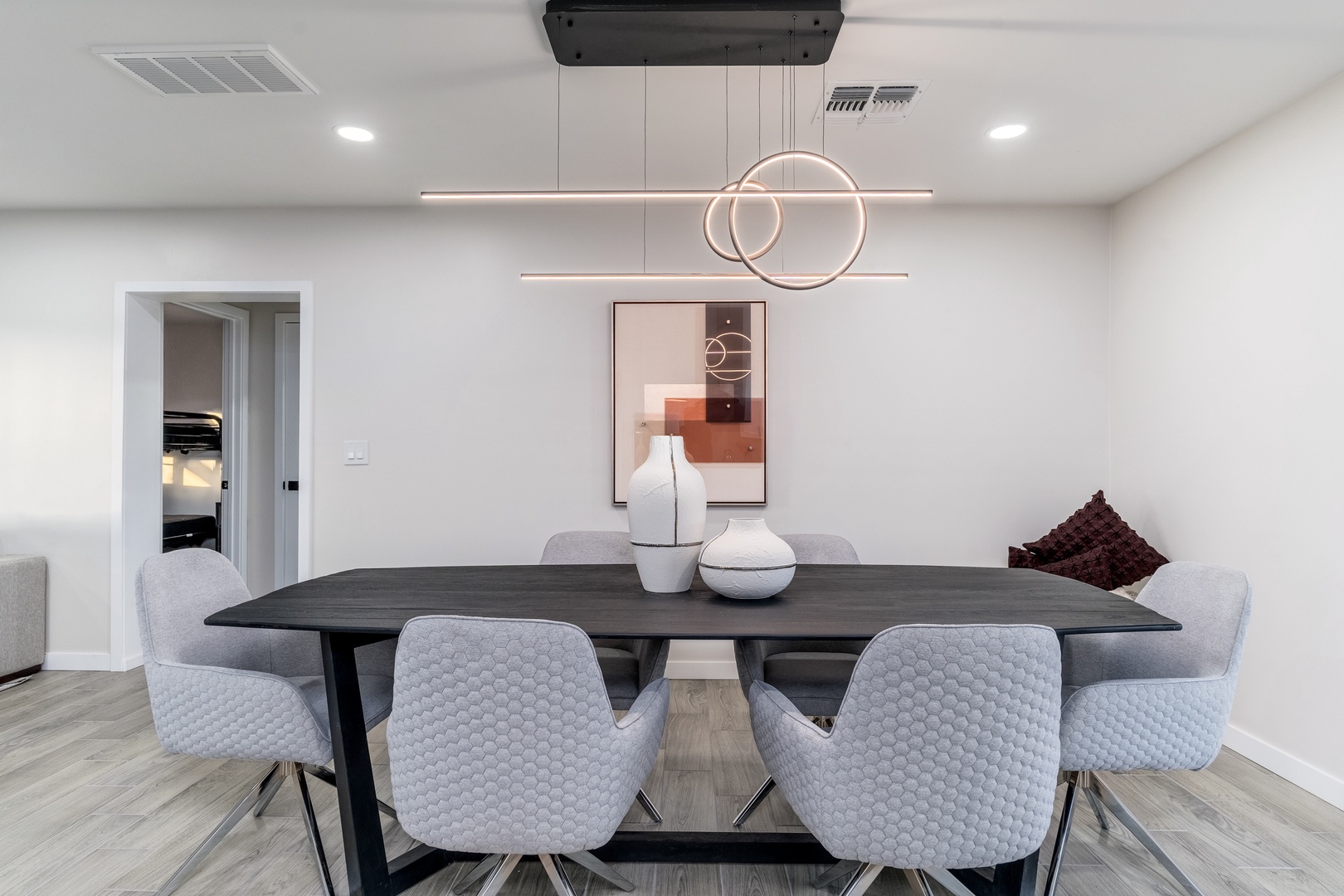 Gather around this sleek dining table where shared meals and laughter await. The modern lighting sets the perfect mood for your evenings together.