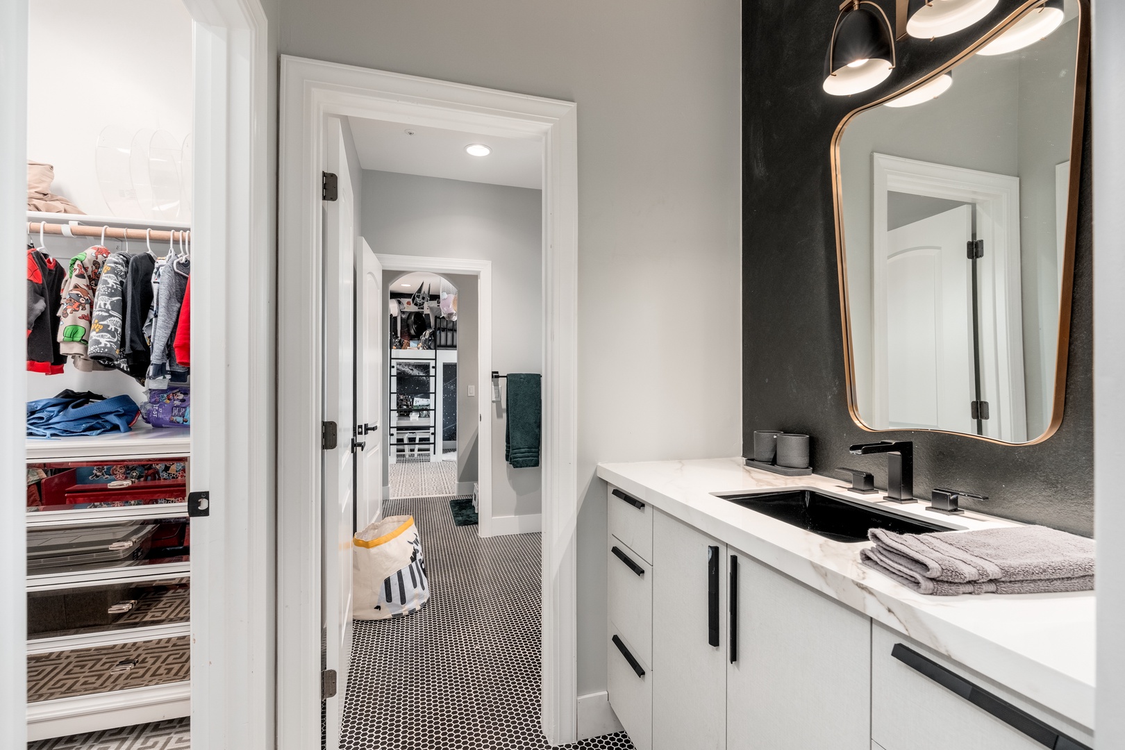 Freshen up in your private bathroom with modern fixtures, chic gold accents, and soft towels—plus convenient closet space to unpack and settle in.