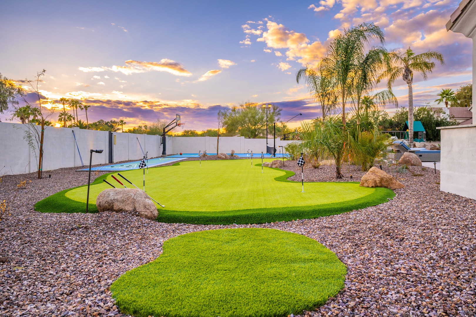 A custom backyard putting green awaits beneath dramatic desert skies and swaying palms—practice your swing in warm Arizona sunshine or under painted sunset clouds.