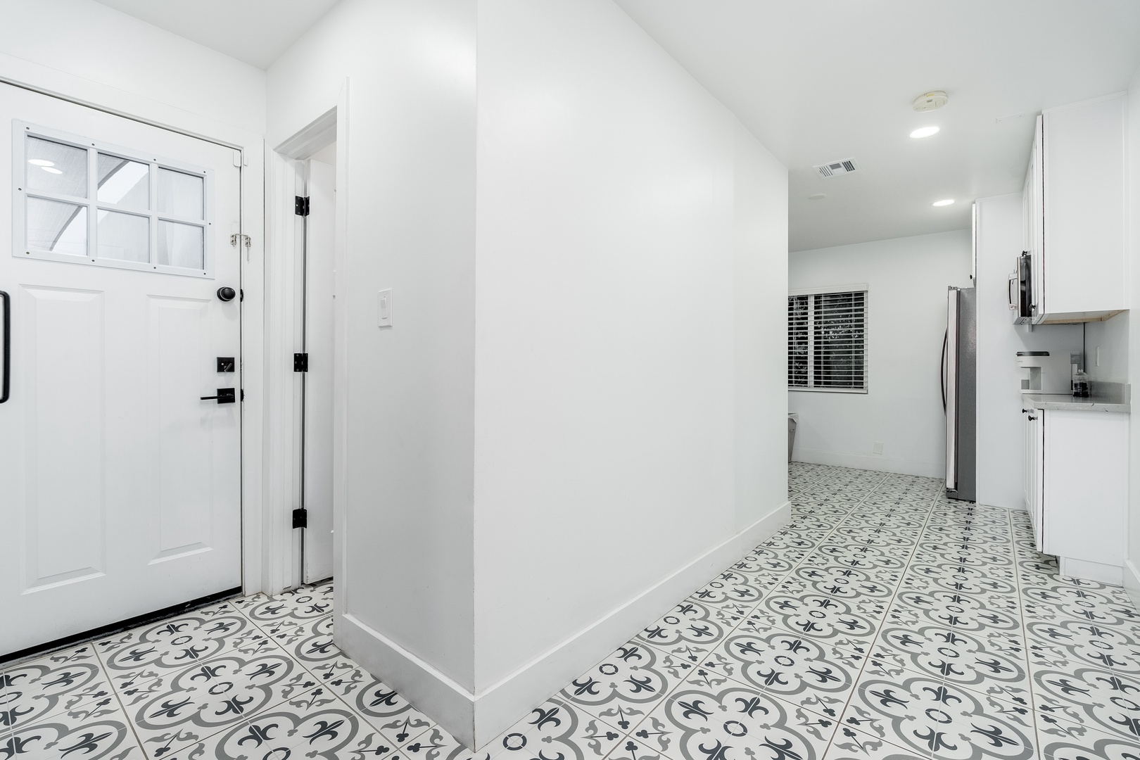 Stunning patterned tile greets you at entry, flowing from the doorway through this bright, open space and into your modern kitchen area.