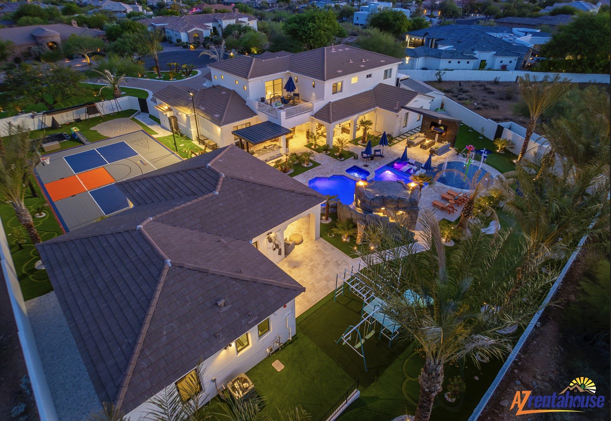 Stunning aerial view showcases this luxury estate with resort-style pool, sports court, and expansive grounds in a peaceful residential setting.