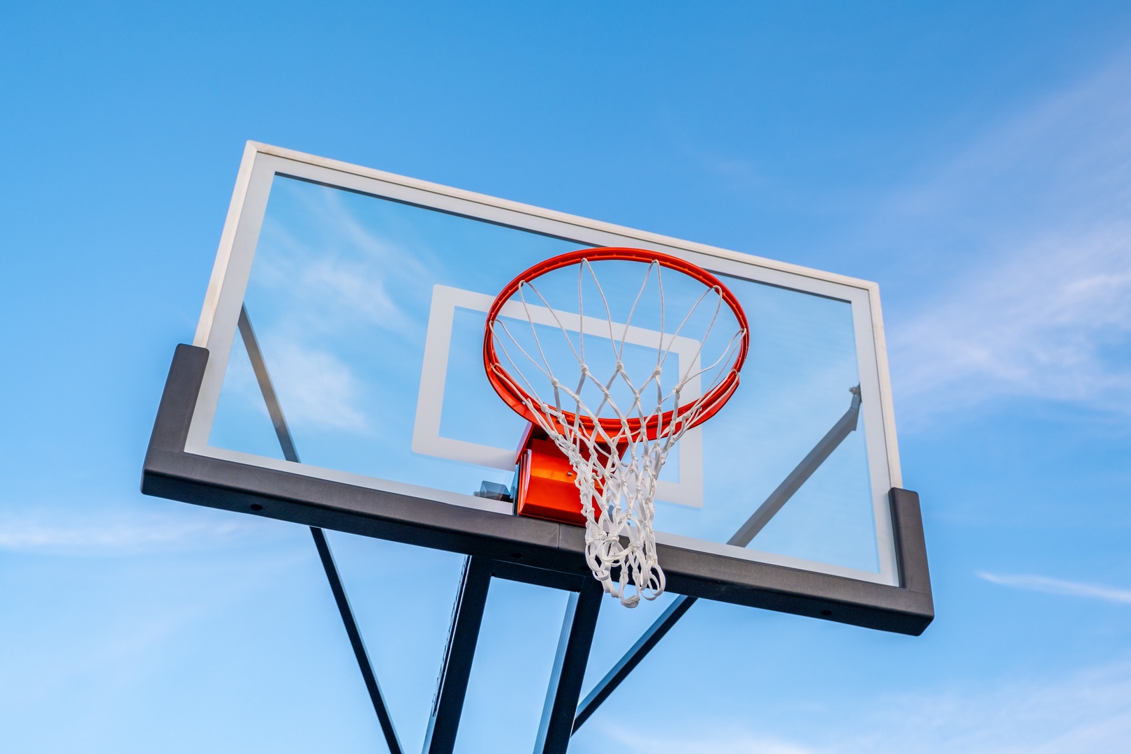 A basketball hoop stands ready against clear blue skies, offering fun outdoor recreation during your stay.