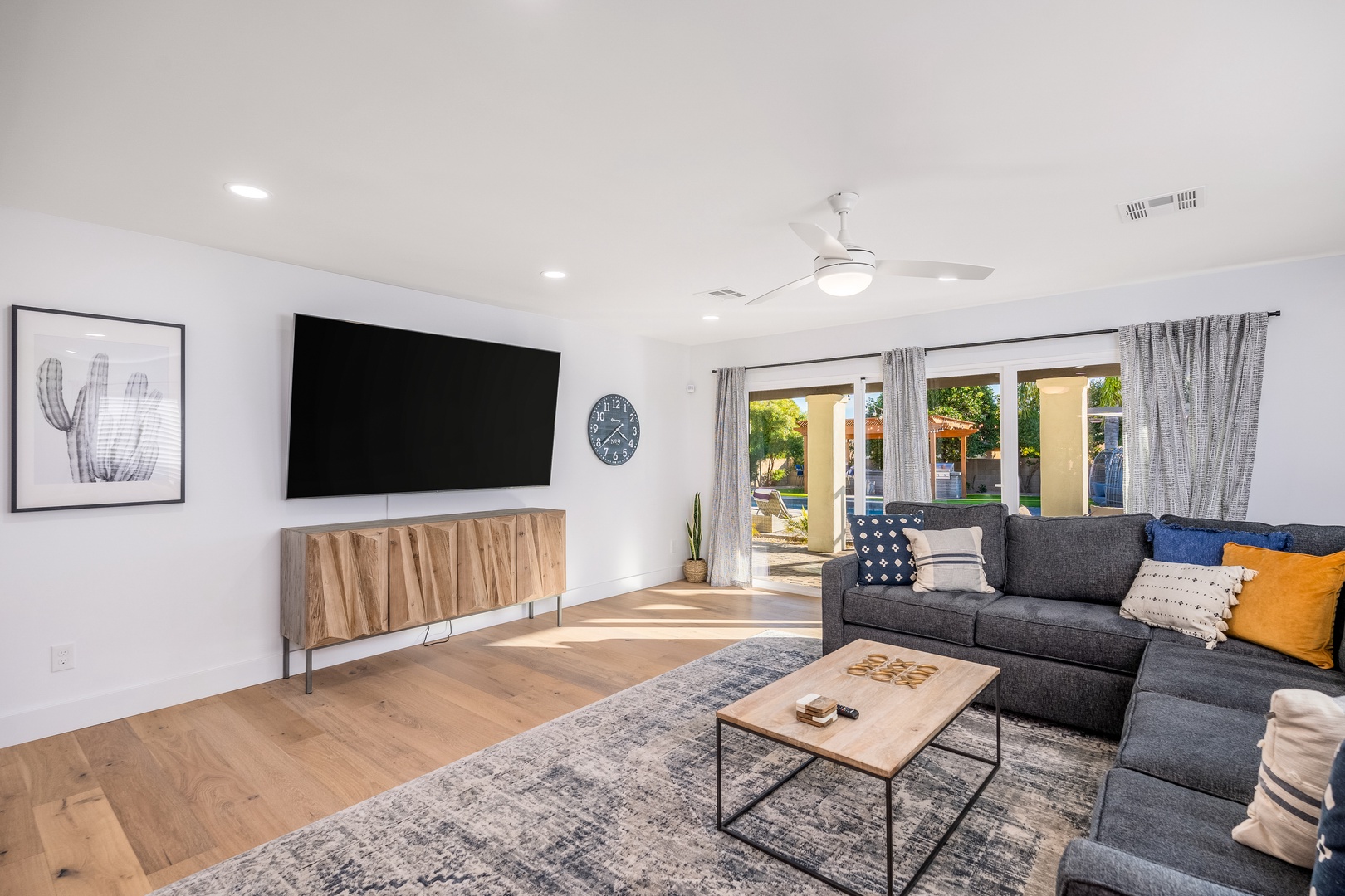 Sink into plush seating beneath the gentle breeze of your ceiling fan while enjoying your favorite shows on the large flat-screen TV. Natural light and garden views create a serene backdrop.