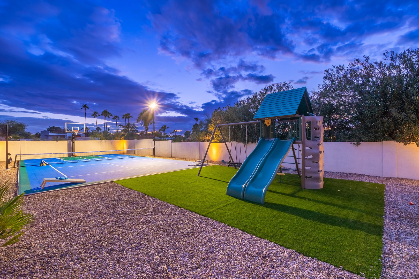 The backyard offers a private playground, basketball court, and pool—perfect for family fun under desert skies that paint unforgettable twilight memories.