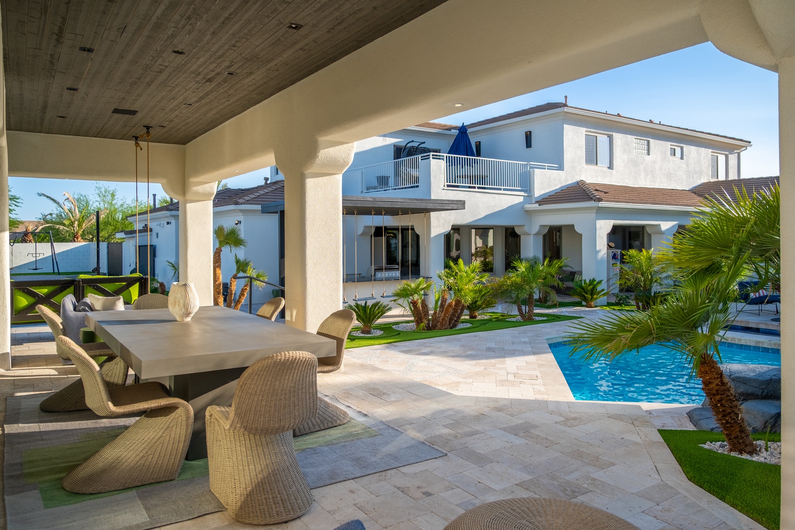 Step onto your private covered patio, where elegant dining awaits beside a sparkling pool and lush tropical palms—your ideal retreat for warm afternoons and peaceful evenings.