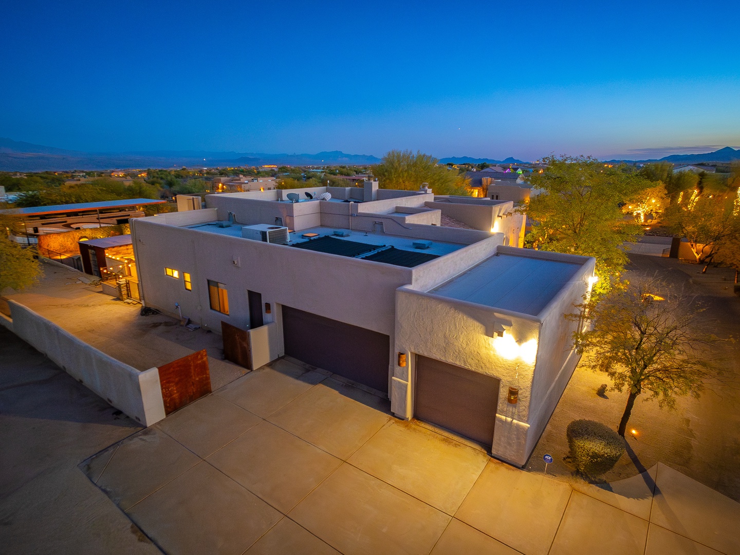 Contemporary desert architecture nestled in the Sonoran landscape, captured during the serene transition from sunset to twilight with ambient outdoor lighting and mountain views.