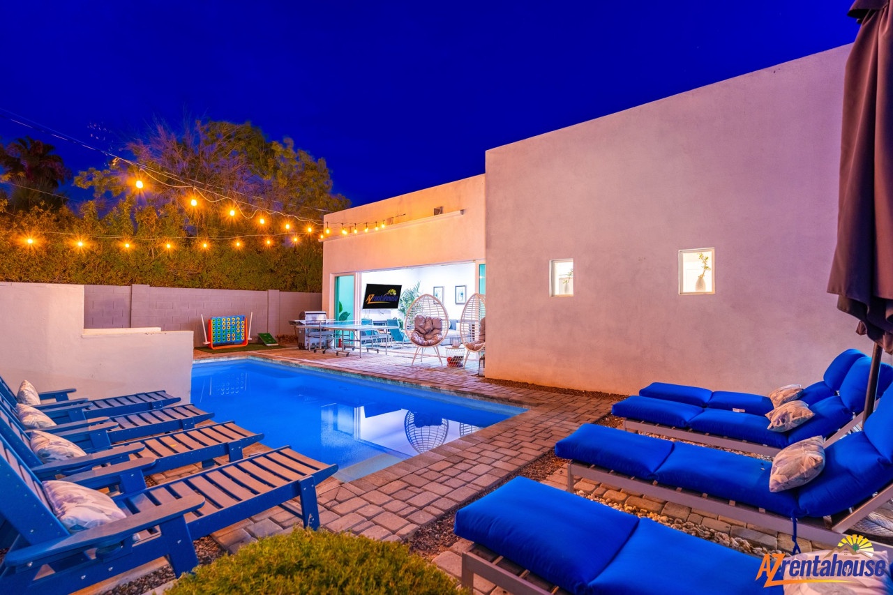 Your private poolside paradise awaits with twinkling lights overhead and cozy loungers for evening relaxation under the stars.