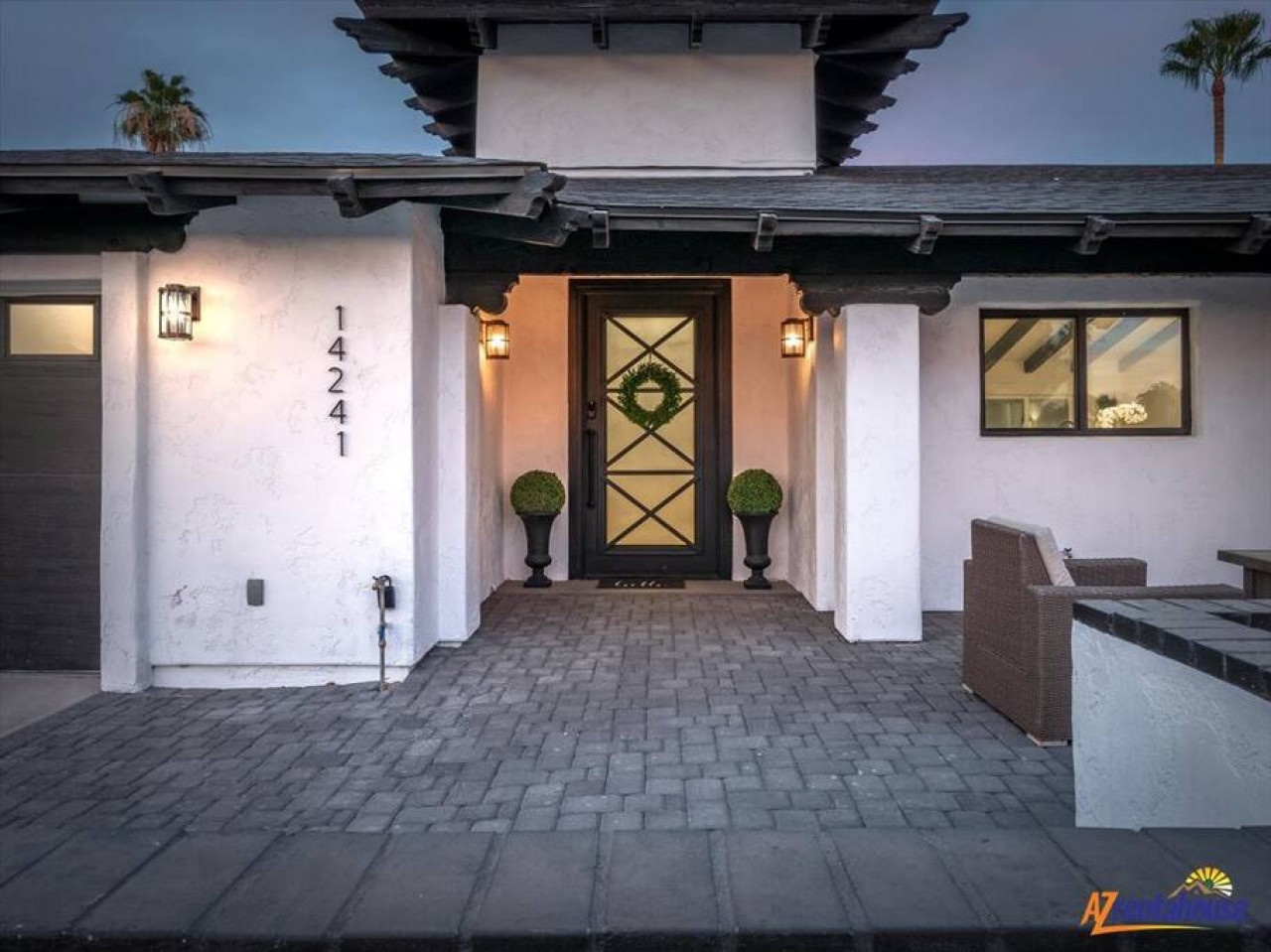 Elegant desert modern facade features warm lighting and beautifully landscaped entrance with contemporary architectural details.