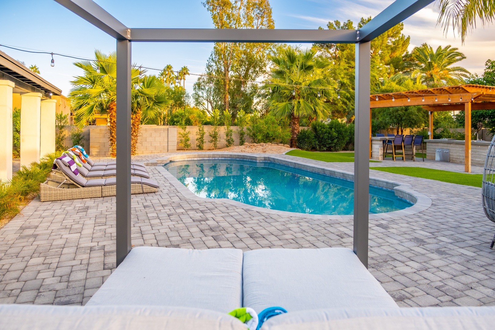 Your private backyard oasis awaits—lounge poolside under swaying palms, take a refreshing dip, or gather under the covered patio for alfresco dining. Pure desert paradise.