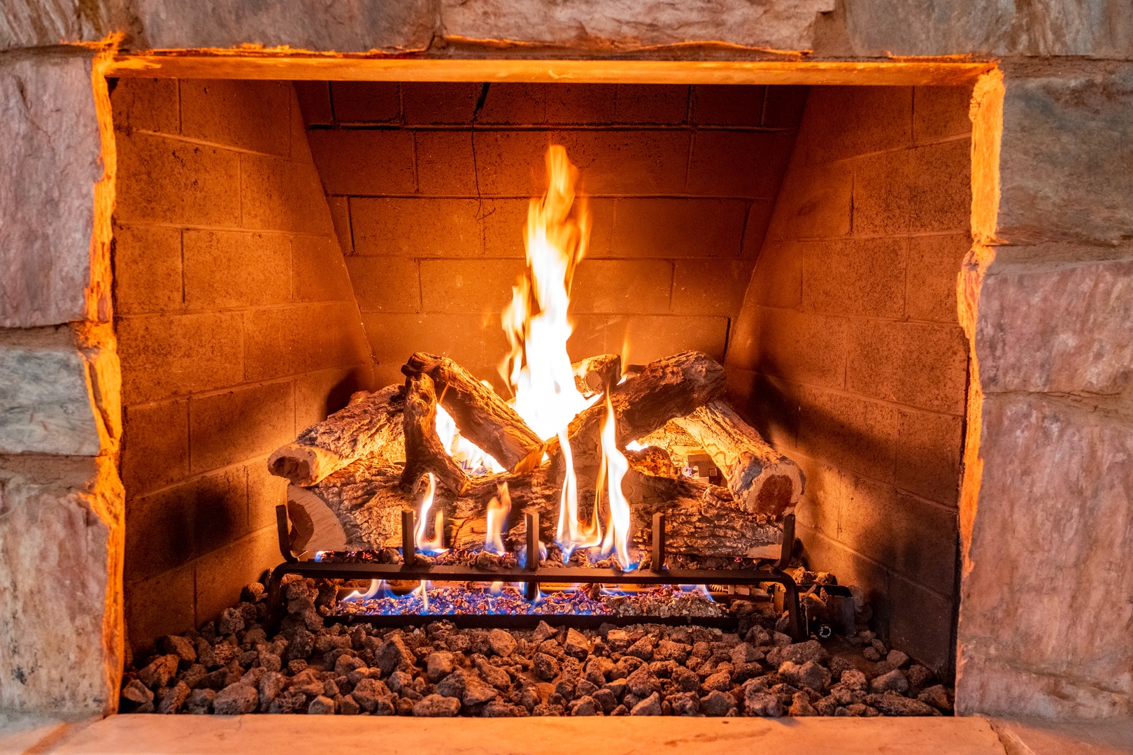 A stone fireplace crackling with warmth invites you to unwind after your adventures, creating the perfect cozy atmosphere for relaxation.