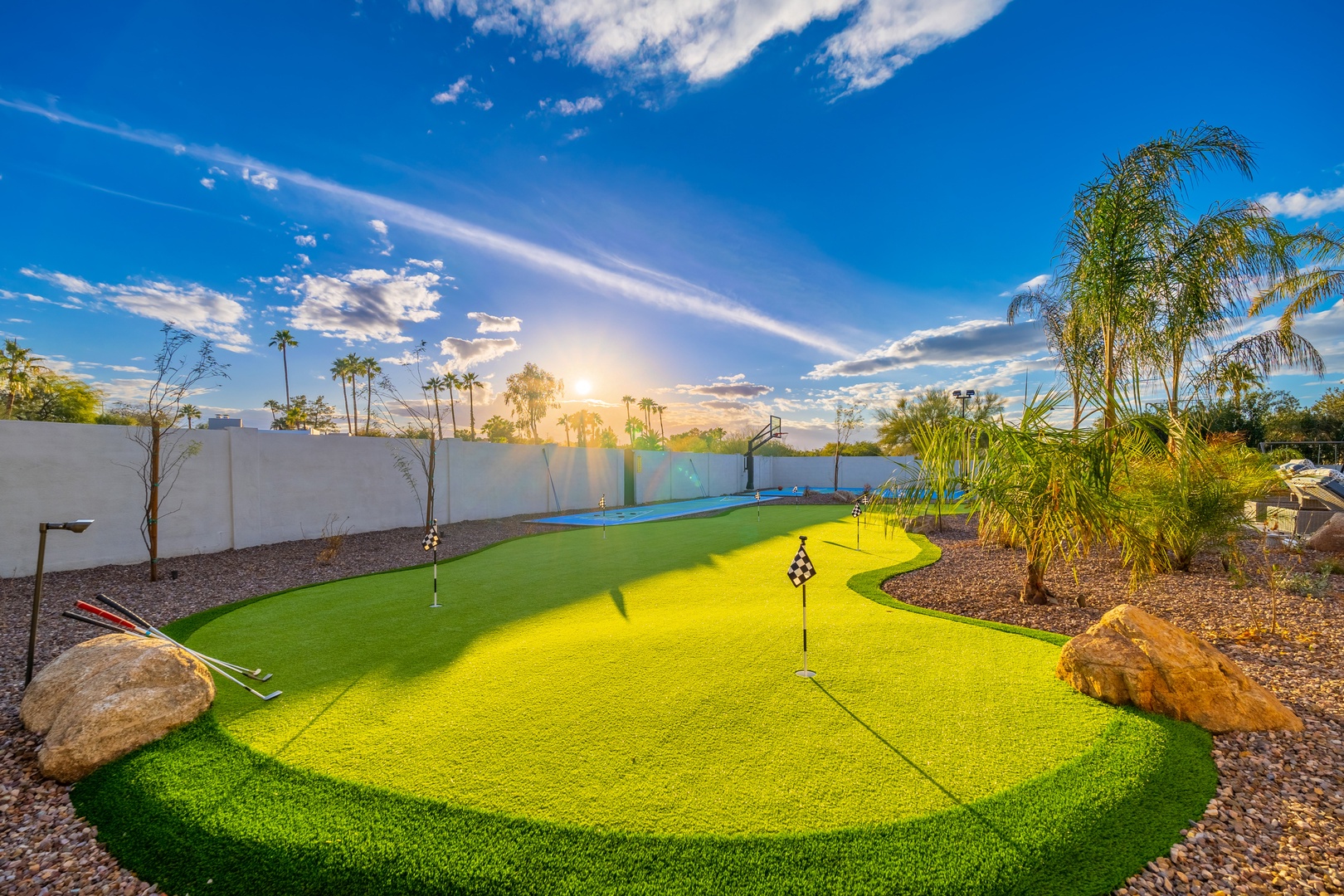 Practice your swing under warm desert sunshine on this private putting green, framed by lush palms and mountain views—your personal oasis for relaxation and play.