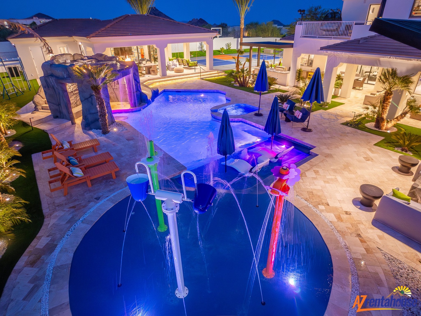 Luxurious pool complex with vibrant LED lighting, featuring a hot tub, waterslide, and swim-up bar for unforgettable evenings.