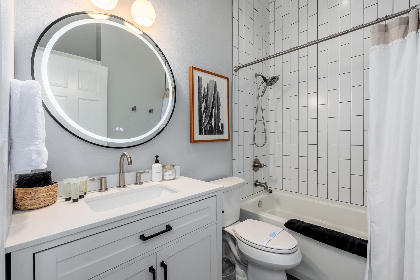 Relax in your modern bathroom featuring a sleek soaking tub, walk-in shower with dual showerheads, and chic vanity with LED mirror lighting—fresh towels await your arrival.