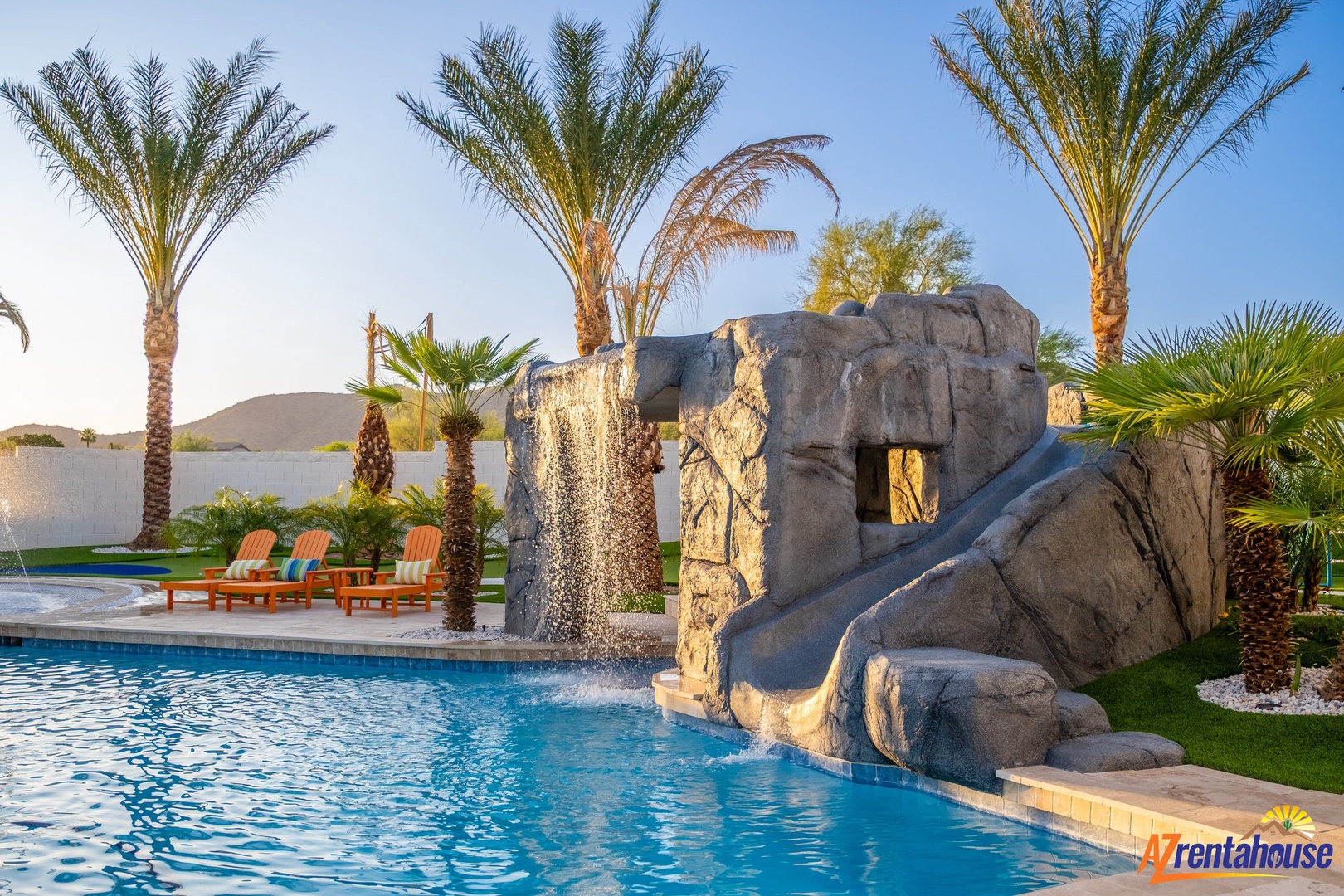 Dive into luxury with your private oasis featuring a stunning rock waterfall and slide surrounded by swaying palms.