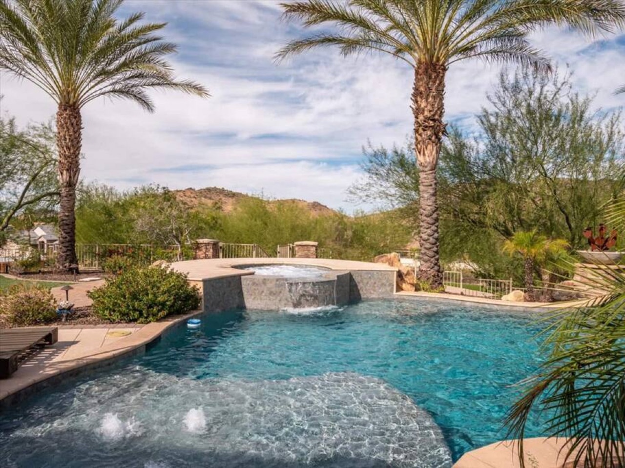 Stunning desert oasis pool framed by swaying palms and mountain views, perfect for sun-soaked afternoons and refreshing dips under endless Arizona skies.