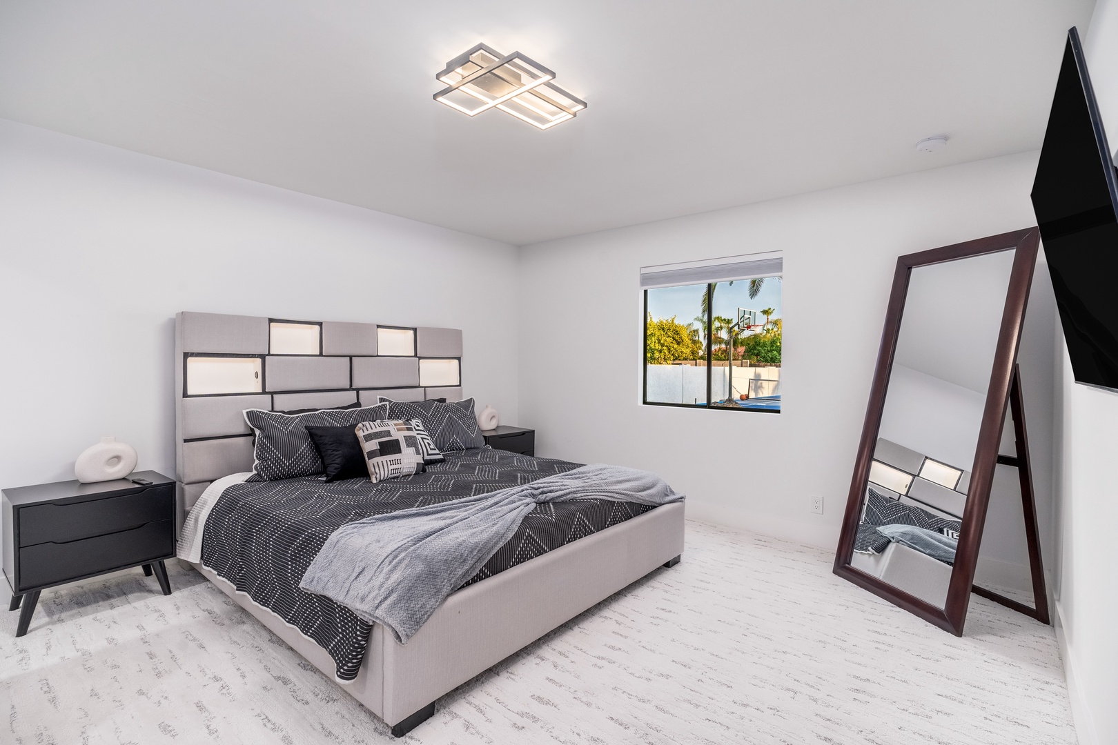 Unwind in your serene bedroom featuring modern design, plush bedding, and a sunny window view that invites natural light into your personal retreat.