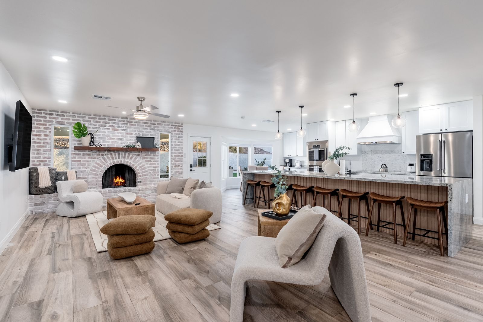Your open-concept sanctuary blends modern elegance with inviting warmth. Sink into plush seating by the brick fireplace, or gather with friends at the spacious kitchen island beneath stylish pendant lights.
