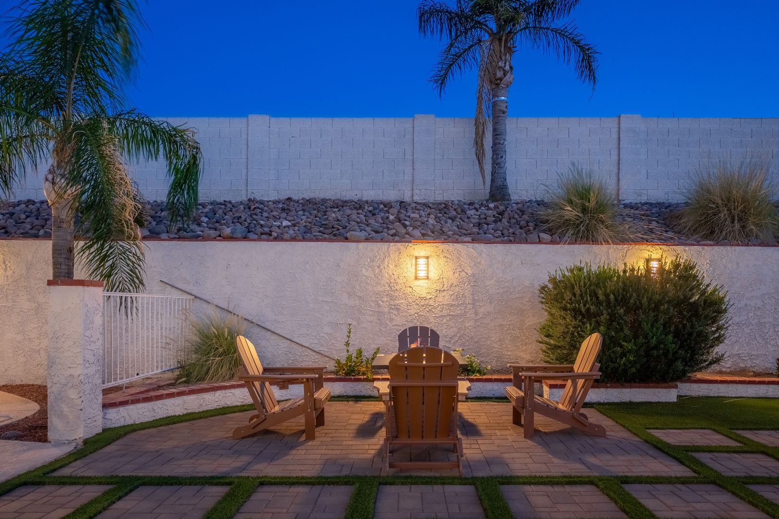 Enjoy warm desert evenings in your private courtyard, where Adirondack chairs await beneath softly glowing sconces and palm trees whisper above carefully manicured landscaping.