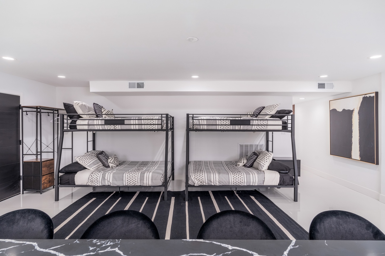 You'll find plenty of sleeping space with two sturdy bunk beds dressed in stylish striped linens, perfect for families or groups looking to maximize comfort in a modern setting.