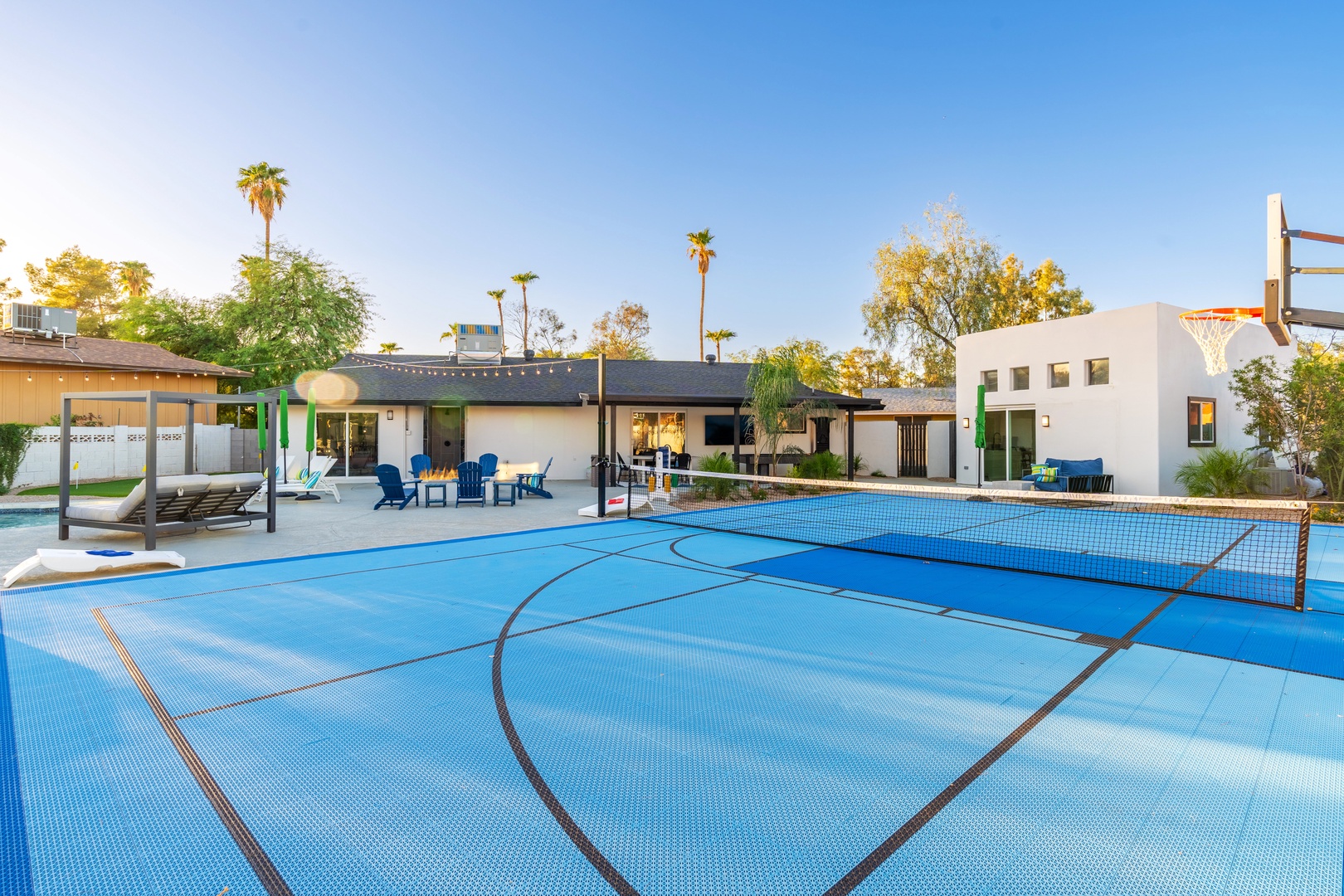 A full-size sport court with basketball and pickleball awaits, surrounded by palm trees and modern architecture, ideal for active days in the sun.