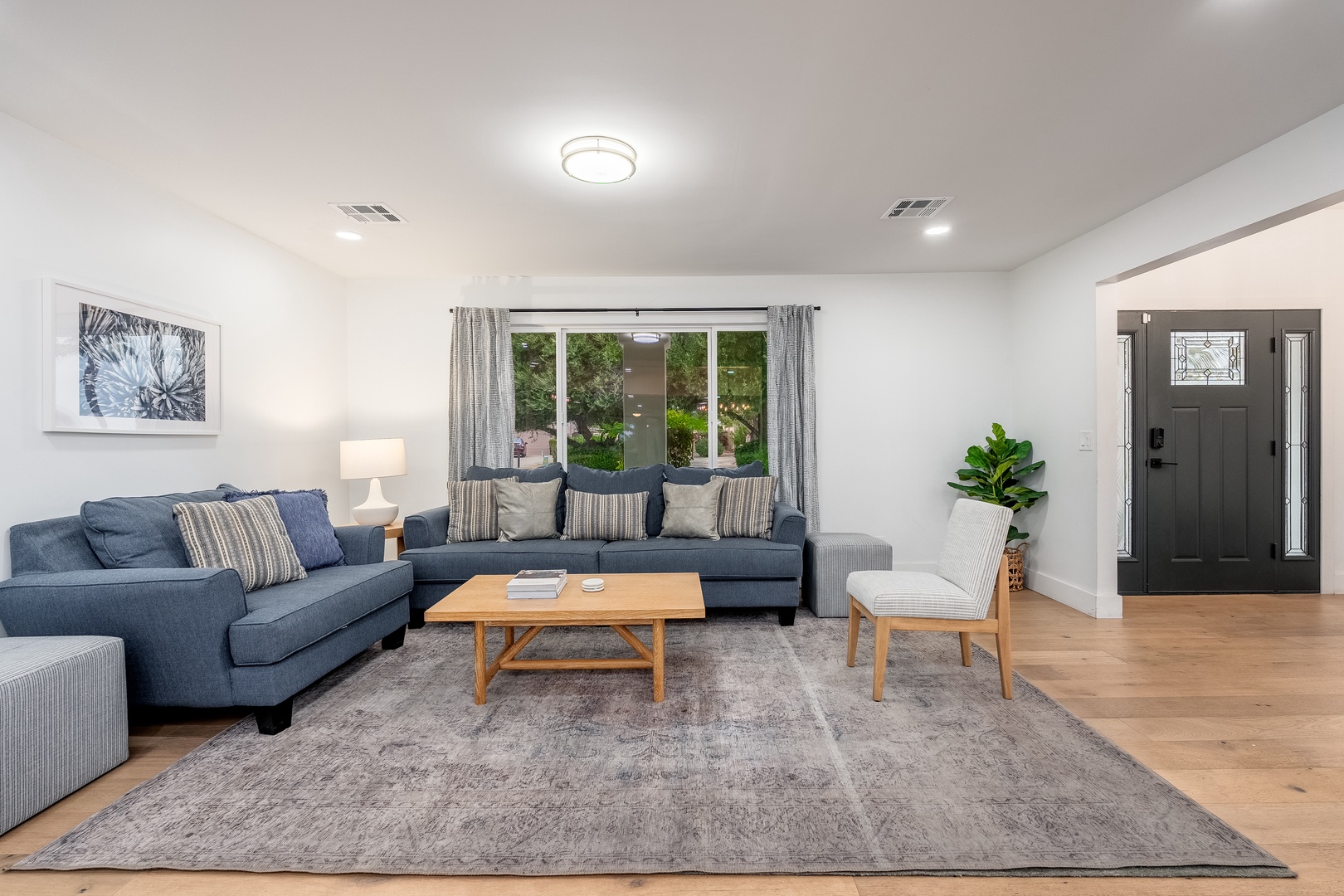 Sink into plush sofas and unwind in your bright, open living space. Large windows frame garden views, while tasteful décor invites relaxation after exploring the area.