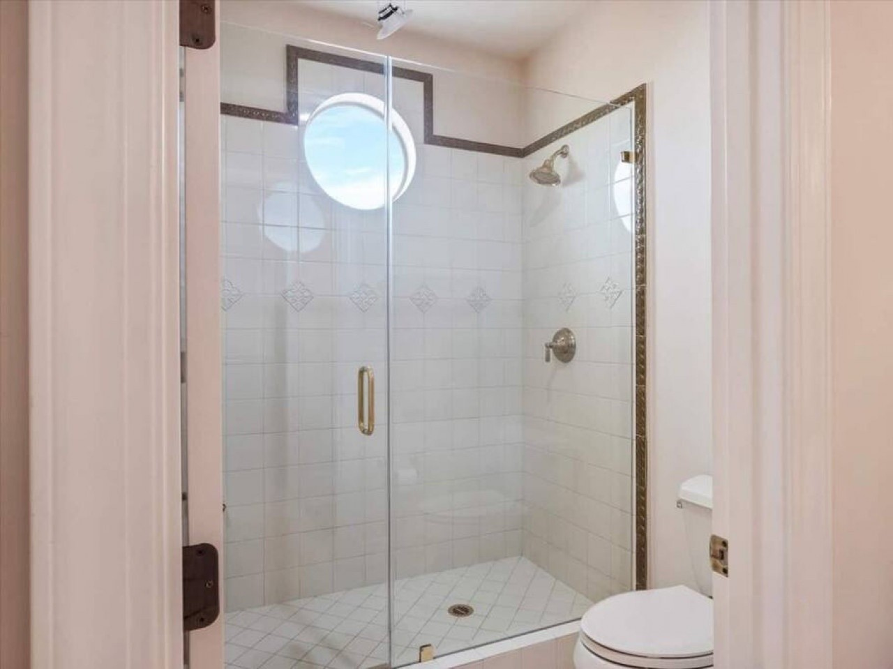 Your private bathroom features a spacious walk-in shower with elegant tiling, decorative accents, and a modern glass enclosure for a refreshing, spa-like experience.