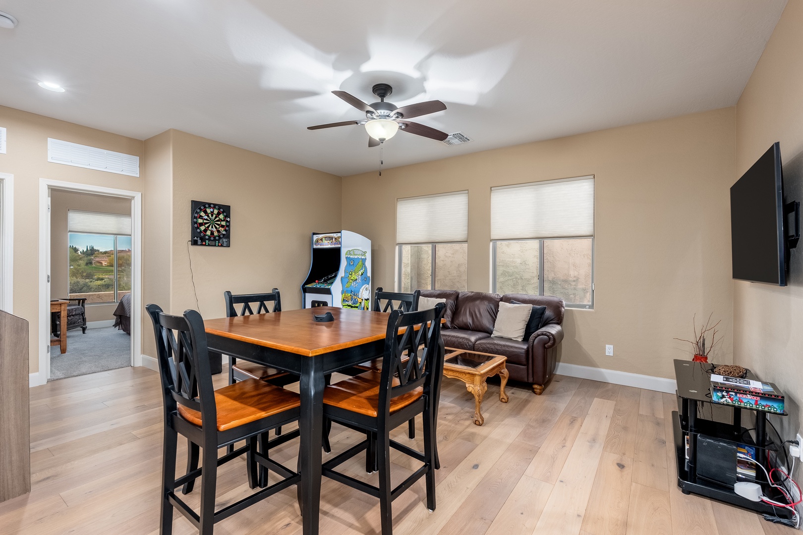 Gather around the stylish dining table for meals and games, or relax on the leather sofa while enjoying your favorite shows on the wall-mounted TV in this bright, inviting space.
