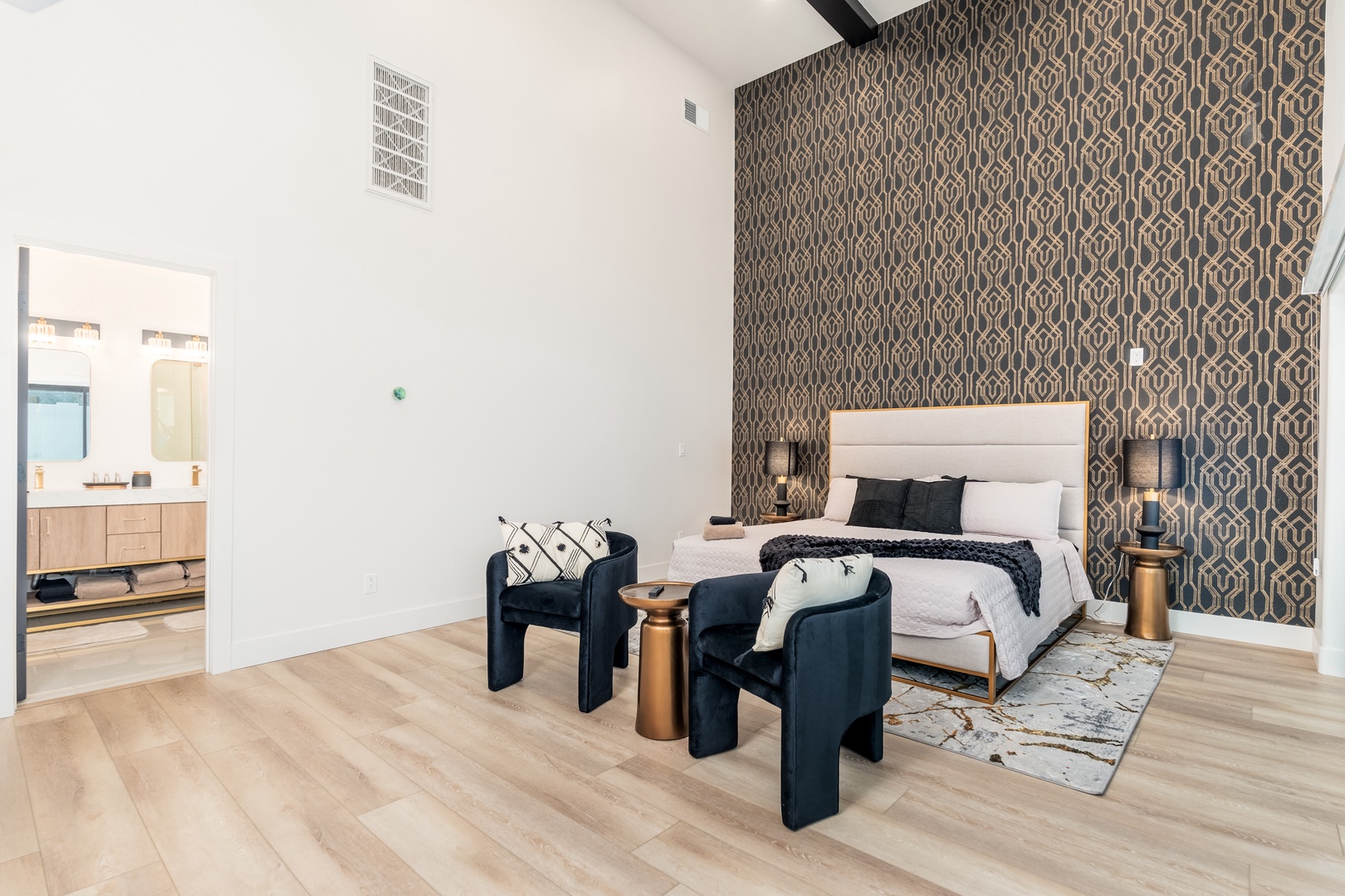Your stylish retreat features soaring vaulted ceilings, a plush king bed with statement wallpaper, and an elegant ensuite—modern comfort meets sophisticated design in every detail.