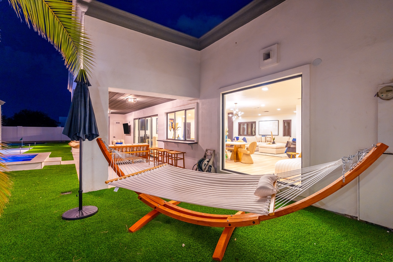 Sink into your hammock under the stars, just steps from your warmly lit living room. The open design invites you to drift between indoor comfort and the peaceful evening air.